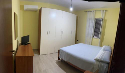 a bedroom with a bed and a cabinet and a television at Casa in Crotone
