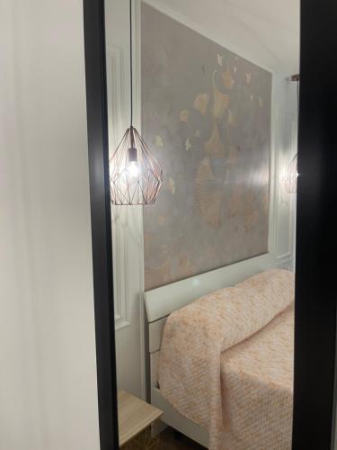 a room with a bed and a lamp and a wall at Amantea Monument in Terrasini