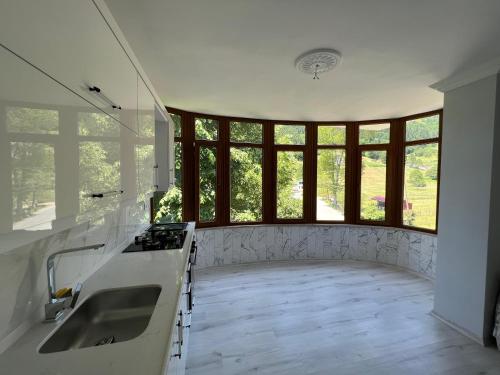 eine Küche mit einem Waschbecken und einem großen Fenster in der Unterkunft Fanus Cafe Konaklama & Restorant in Düzköy