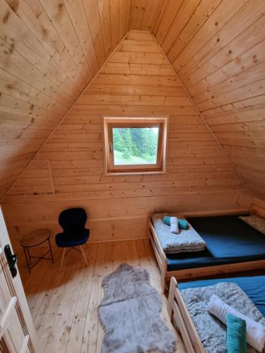 a room with two beds in a wooden cabin at Domek w drapie in Lubomierz