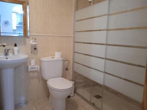 a bathroom with a toilet and a sink at Vista al Mar with Parking Space in La Mata