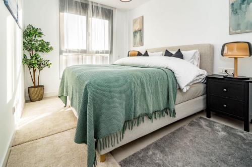 Un dormitorio con una cama con una manta verde. en LME101A- Apotel Las Mesas by Roomservices, en Estepona