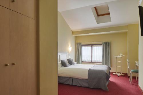 a hotel room with a bed and a window at IRAIPE Ongi Hotel Auto Check-in in Oñate