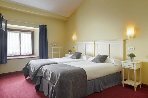 a hotel room with two beds and a window at IRAIPE Ongi Hotel Auto Check-in in Oñate