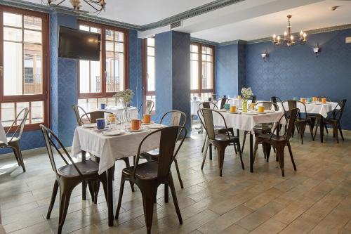 jadalnia ze stołami i krzesłami oraz telewizorem w obiekcie IRAIPE Ongi Hotel w mieście Oñate
