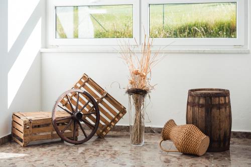 a table with a wooden wheel and a vase with flowers at HOTEL AGRI in Soběšice