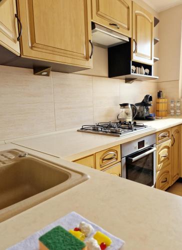 a kitchen with a sink and a stove at Parkowy - Sweet House in Świnoujście