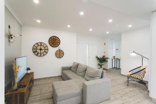 a living room with a couch and a clock on the wall at Best Houses 80 - Peace House in Ferrel