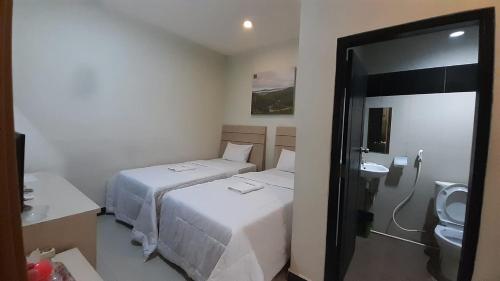 a hotel room with two beds and a bathroom at Galaxy Inn in Baubau