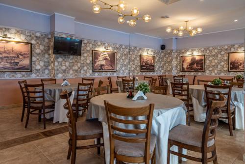 a dining room with tables and chairs and a tv at Detelina Hotel in Golden Sands