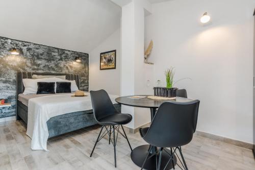 a bedroom with a bed and a table and chairs at Apartment Simunic Punta in Bibinje