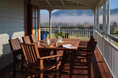 a wooden table and chairs on a porch at Cookes Road Cottage at Conondale in Conondale