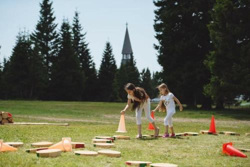 a woman and a girl playing a game in a field at Rogla - Chalet Mojca Pokrajculja in Zreče