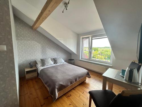 ein Schlafzimmer mit einem großen Bett und einem Fenster in der Unterkunft Dom Gościnny 10tka Juliana in Łeba