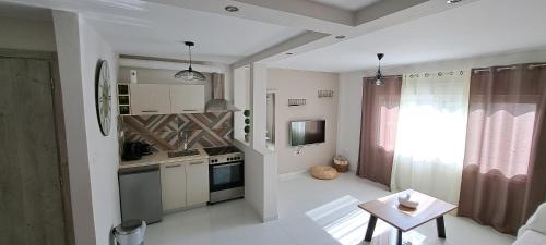 eine Küche mit einem kleinen Tisch und eine Küche mit einem Fenster in der Unterkunft Xylokastro cozy apartment in Xylokastro