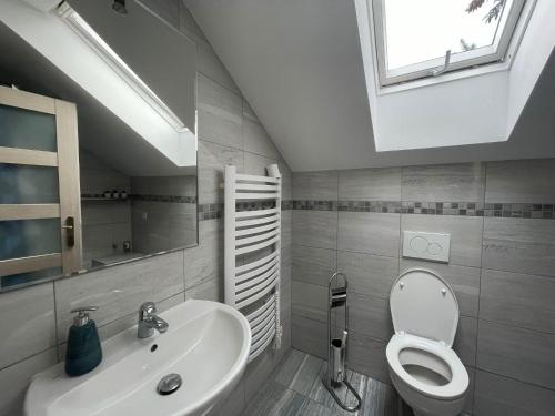 baño con lavabo y aseo y ventana en Apartmán z wellnes, en Bratislava