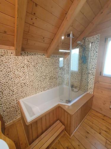 une grande salle de bain avec baignoire et douche dans l'établissement La Mazzonette - 4* chalet in de natuur met hottub, à Dommartin-lès-Remiremont