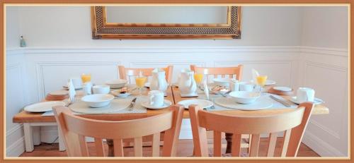 a dining room table with chairs and a table with plates and cups at Jordan's Drum Haven B&B, Knock in Knock