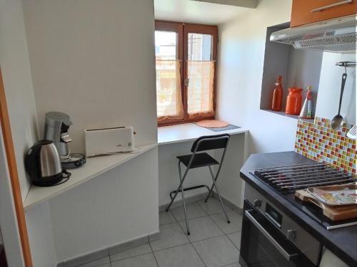 - une cuisine avec un comptoir et une cuisinière four supérieur dans l'établissement Studio meublé et tout équipé, à Die