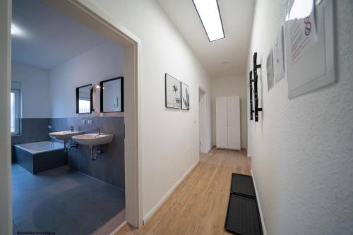 - une grande salle de bains avec deux lavabos et un miroir dans l'établissement DQ03 - Geräumige Monteurwohnung Koblenz, à Coblence