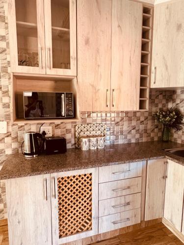 a kitchen with white cabinets and a microwave at Mont Pelaan 88 in Newcastle