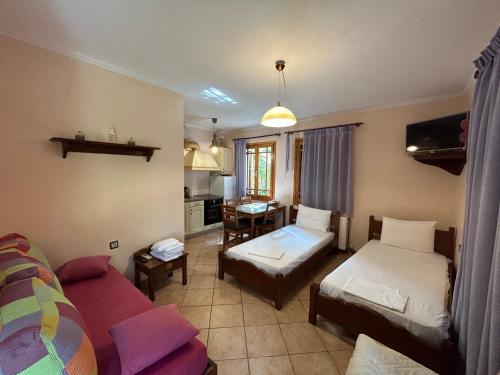 een woonkamer met 2 bedden en een bank bij Διαμέρισμα 4 ατόμων-Cozy Family apartment close to the most beautiful beaches in Athanion