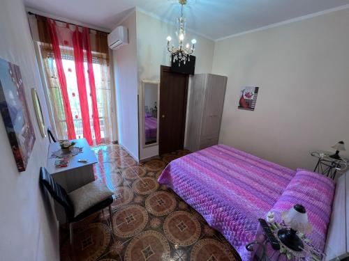 a bedroom with a pink bed and a chandelier at B&B EMPIRA Lamezia Terme in Lamezia Terme