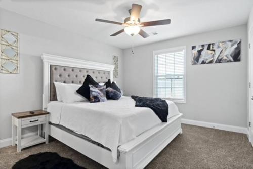 a bedroom with a white bed with a ceiling fan at Stay Happy in Clarksville