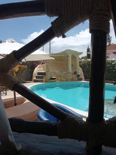 a view of a swimming pool from a hammock at Boutique Hotel Nyumbani Tembo in Watamu