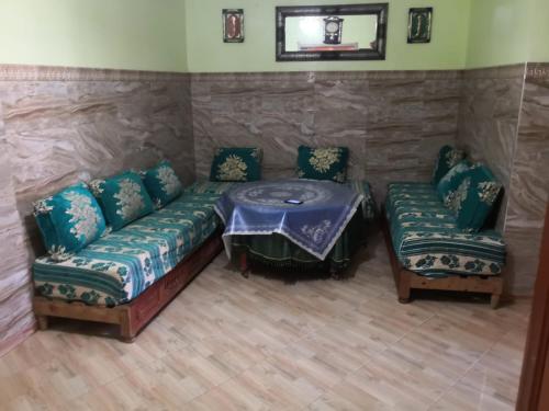 een woonkamer met een bank en een tafel en stoelen bij Family house 2 bedrooms, 2 sdb, near Center of Nador & Airport in Selouane