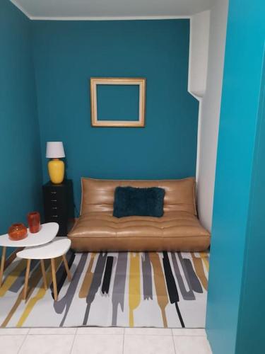 sala de estar con sofá marrón y pared azul en Casa Vacanze Viale Miramare 31- Delizioso mini loft industrial, en Trieste