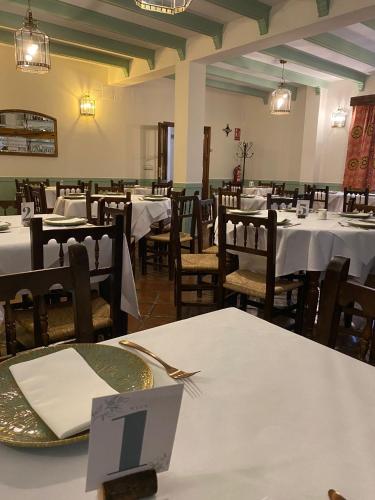a dining room with white tables and chairs at Hospederia Casa de las Piedras in Grazalema