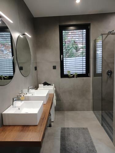 a bathroom with three sinks and a shower at Aparthotel Villa V with breakfast and free parking in Rijeka