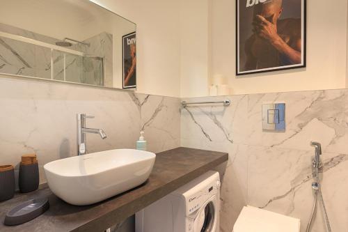 La salle de bains est pourvue d'un lavabo et d'un miroir. dans l'établissement Dolce Vita Baveno - By Impero House, à Baveno