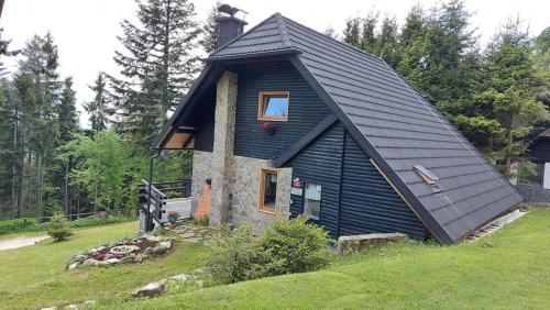 a small house with a black roof on a hill at Rogla - Chalet Mojca Pokrajculja in Zreče