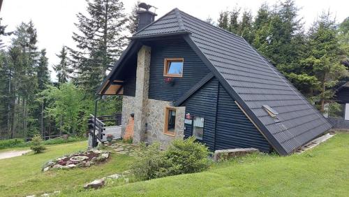 a small house with a black roof on a hill at Rogla - Koča Mojca Pokrajculja in Zreče