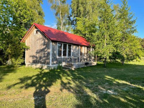 a small cabin with a red roof in a field at JUST Lodges in Orissaare