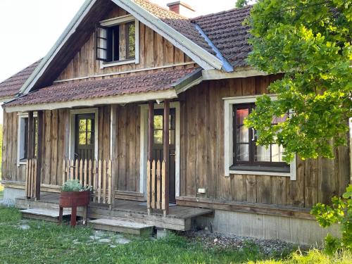 a small wooden house with a porch at JUST Lodges in Orissaare