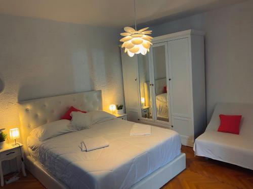 a bedroom with a white bed and a chandelier at City Square Apartment in Poreč