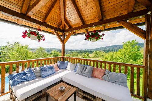 a couch on a deck with a view of the mountains at Jankovi Dvori in Rakovica