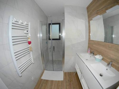 ein weißes Bad mit einem Waschbecken und einer Dusche in der Unterkunft Charming cottage only 8 minutes from Etretat in Bordeaux-Saint-Clair