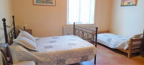 een slaapkamer met 2 bedden en een raam bij Gîte les Marronniers 