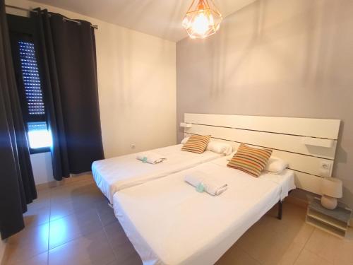 1 dormitorio con 2 camas y toallas. en Expoholidays - Apartamento Auditorio Roquetas, en Roquetas de Mar