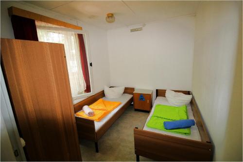 a small room with two beds and a window at DDR Bungalow direkt am Strand auf Rügen in Dranske