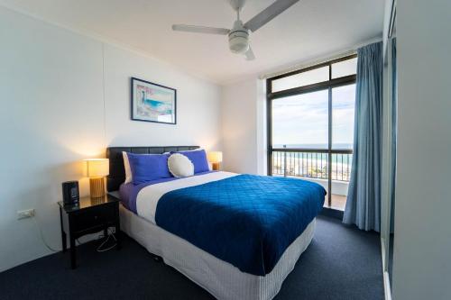 a bedroom with a bed and a large window at Spectacular Central Surfers Beach Views from Apartment in Gold Coast