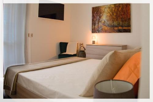 1 dormitorio con 1 cama y una pintura en la pared en Your Place By The Lake - near Leonardo Academy, MXP en Sesto Calende