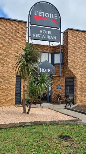 a hotel sign in front of a brick building at Hôtel L'Etoile Aéroport - A61 in Carcassonne