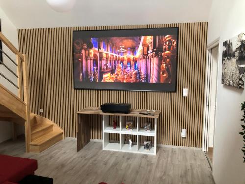 a living room with a flat screen tv on a wall at L'escapade champenoise in Villers-Marmery