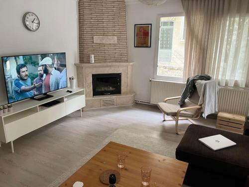 a living room with a large television and a fireplace at 250 m walking distance to metro in Burunabat