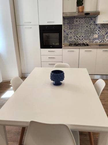 a white table in a kitchen with a blue bowl on it at MARÈ Terracina Suites in Terracina